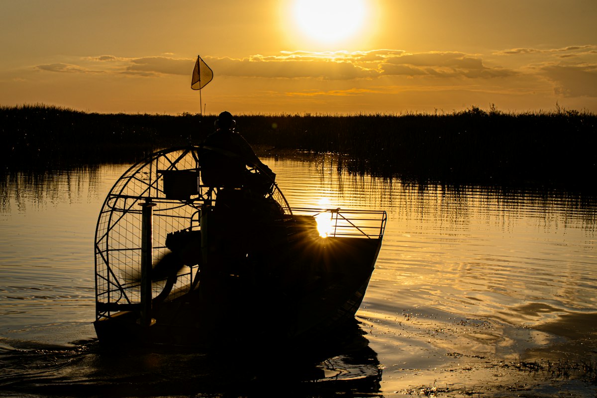 Airboat on still water at sunset in the Everglades